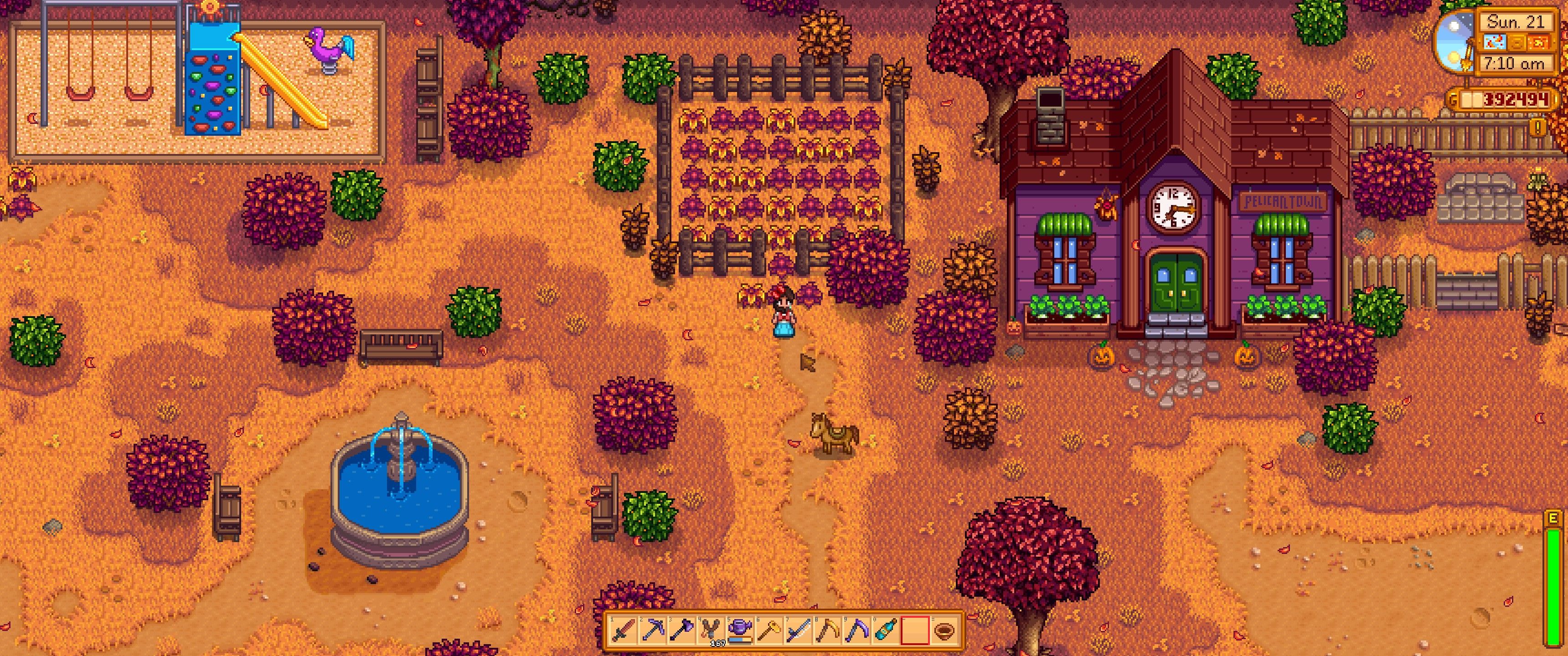 Stardew Valley: The player stands in front of the fenced area by the community center